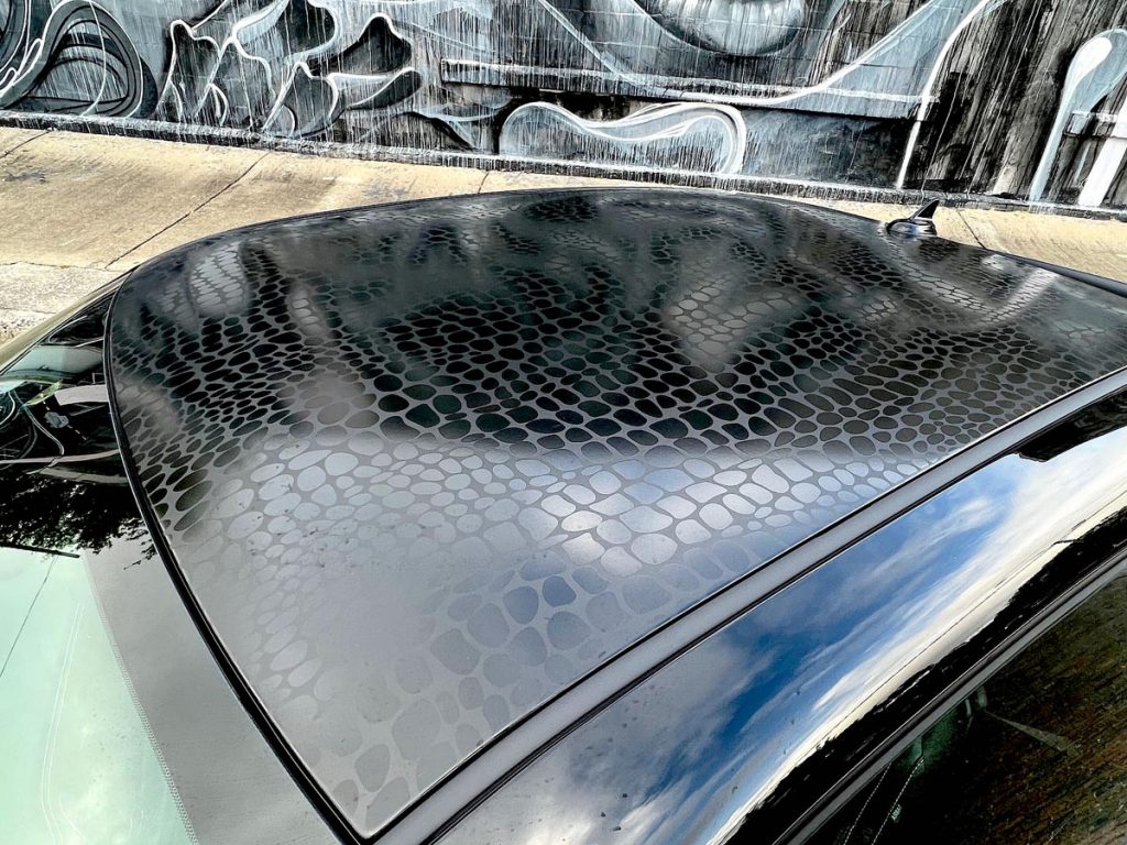 2023 Dodge Challenger Black Ghost parked, faux gator-skin black vinyl roof.