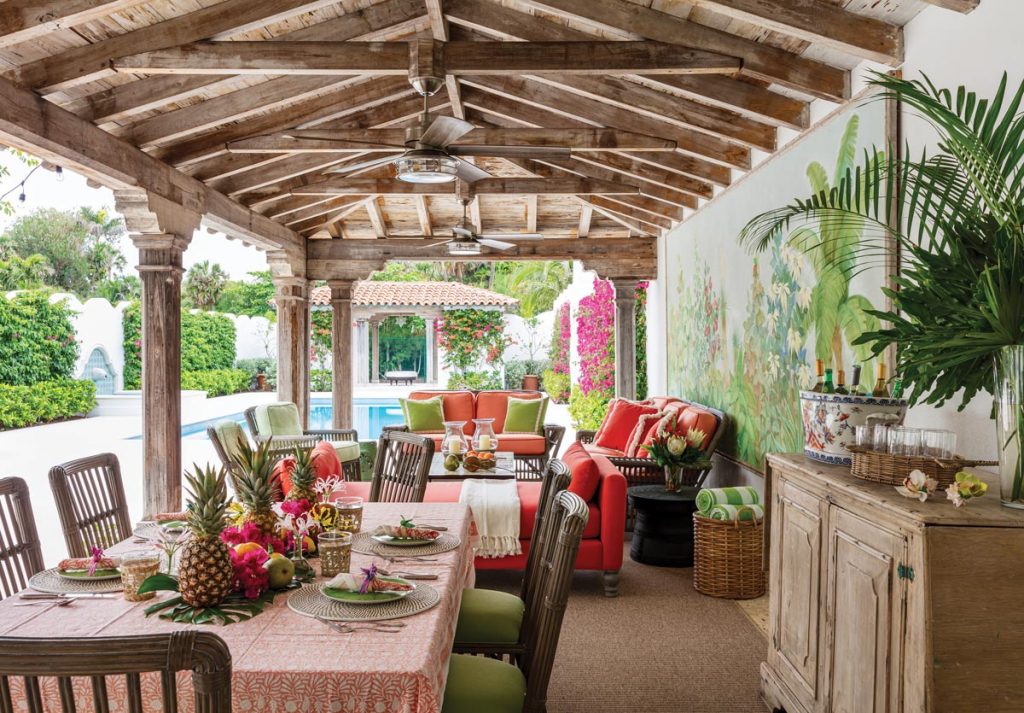 The estate offers ample space for gatherings, including the loggia, which showcases vivid colors set against the backdrop of a large landscape mural. Photo by Nickolas Sargent