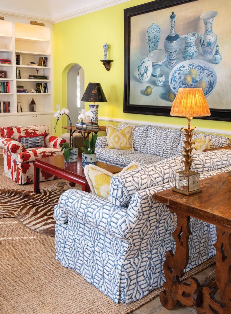 In the living room, painted cypress cabinetry provides ample storage, while the furniture and decor lend an exotic feel, as if collected during travels over time
