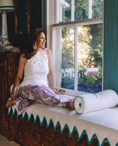 Lange sits on an upholstered window seat with a zigzag trim and faux tortoiseshell wainscoting. Photo by Nick Mele