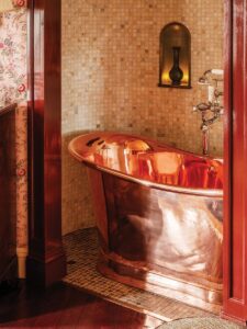 Copper bathtub and bedroom in the “Secret Room,” inspired by Coco Chanel. Photo courtesy of The Fife Arms