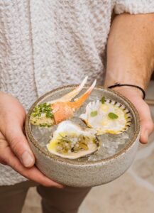Gifts of the Sea daily crudo, oyster, and crab claw at Kaia. Photo by Birch Thomas