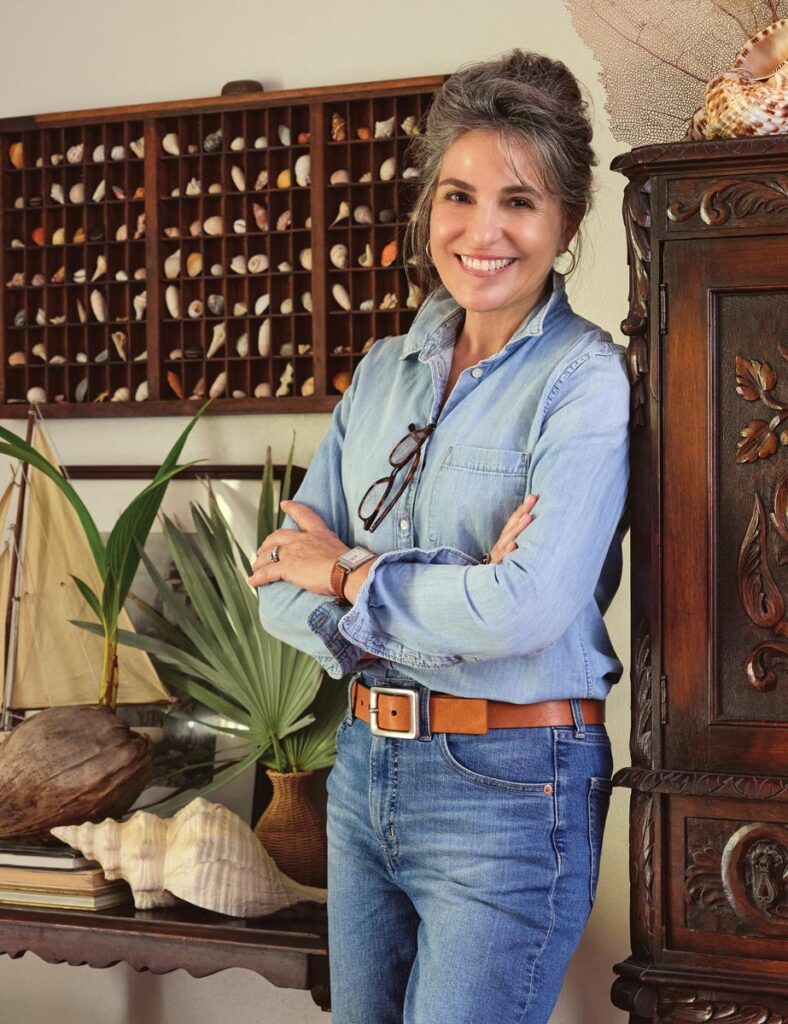 Brantley describes her home in Ocean Ridge, built in the 1970s, as a beach cottage. Here, she stands in front of an old printer’s drawer filled with seashells. After seeing one styled by India Hicks in a magazine many years ago, she went in search of a drawer for herself, finding it in an antique shop in Delray Beach. She now owns six or seven, all filled with seashells she has personally collected. Photos by Carmel Brantley