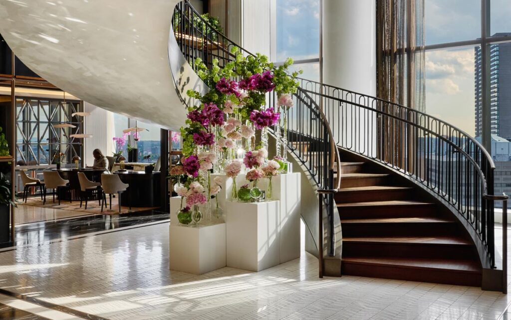 Hover over Boston on the seventeenth-floor Sky Lobby grand staircase at the stunning Raffles Boston. Photo by Joe St. Pierre, courtesy of Raffles Boston